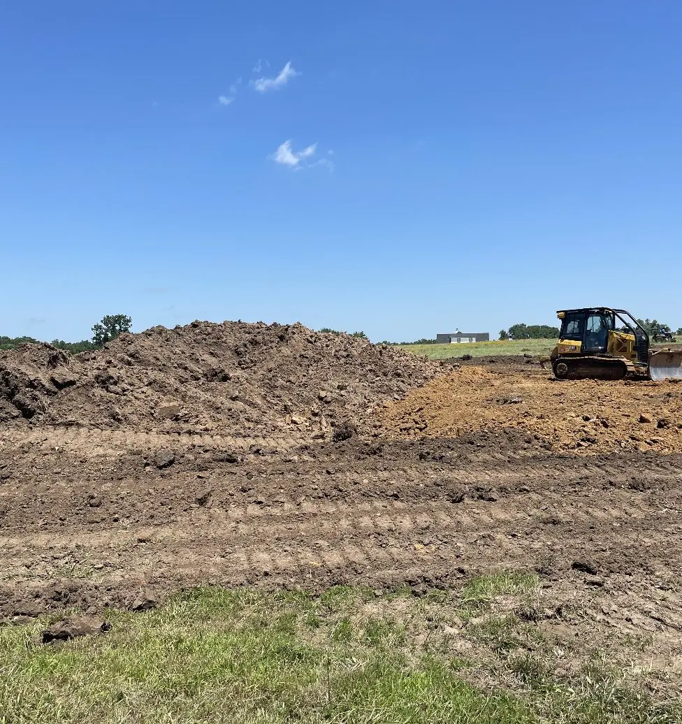 Dozer working beside a long spoil pile on cleared ground